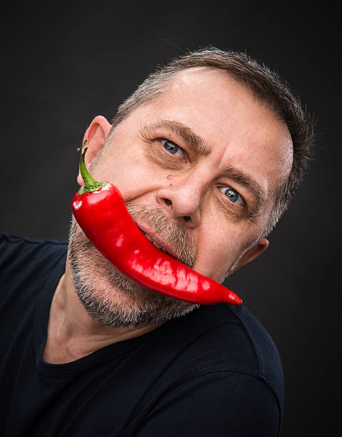 istock elderly man with red pepper in his mouth 178758173