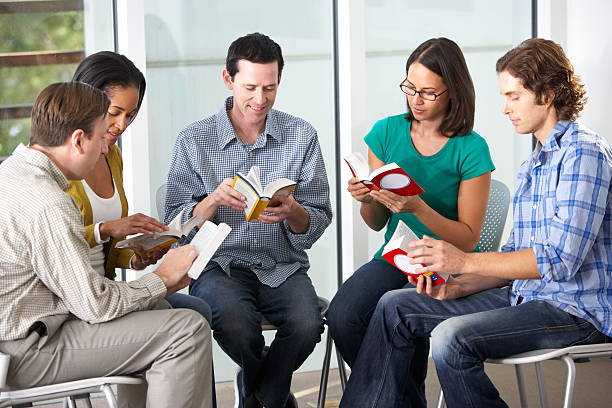 istock Bible group sitting in a circle reading a passage together 178759751