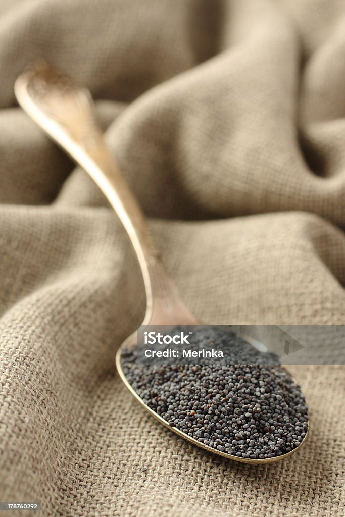 Semi di papavero in un cucchiaio su sfondo sackcloth metallo - Foto stock royalty-free di Agricoltura