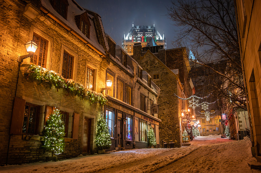 Sous-le-Fort Street in Petit-Champlain District in Old Quebec lower town, illuminated with Christmas winter holidays decorations, Fairmont Chateau Frontenac hotel, Quebec City, Canada (December 2022).