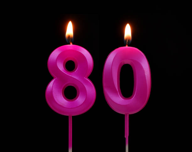 istock Pink birthday candles isolated on black background, number 80 1787611689