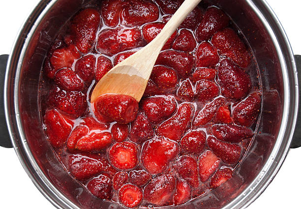 cooking strawberry marmalade preparing strawberry marmalade in a metallic pan compote stock pictures, royalty-free photos & images