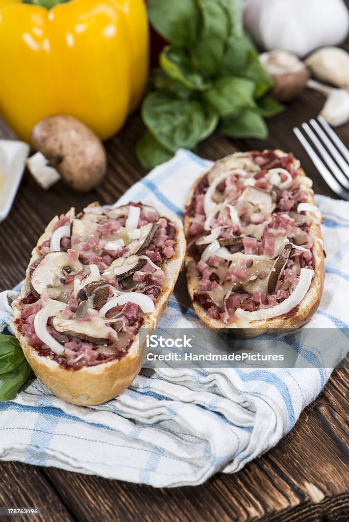 Ham and Mushroom Pizza Baguette Ham and Mushroom Pizza Baguette on wooden background Baguette Stock Photo