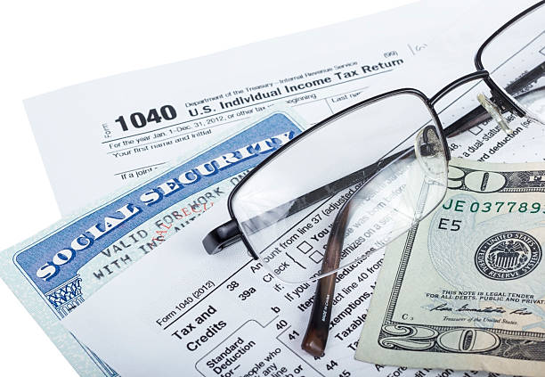 Tax preparation American federal tax form 1040 with money and social security card isolated on white. social security social security card identity us currency stock pictures, royalty-free photos & images