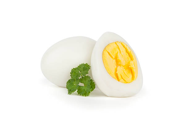 A hard boiled egg, cut in half and garnished with parsley boiled egg isolated on white background boiled egg photos stock pictures, royalty-free photos & images