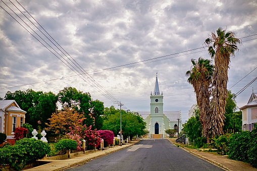 The Dutch Reformed Church (Nederduitse Gereformeerde Kerk in Afrikaans) in the village of Prince Albert, in the heart of the semidesert Karoo region in the province of the Western Cape, South Africa. A moody sky provides an otherworldly light to this village scene.
