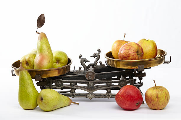 comparar maçãs e peras - weight scale apple comparison balance - fotografias e filmes do acervo