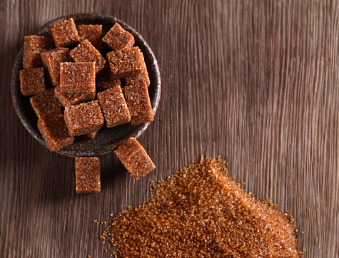 natural brown cane sugar on wooden background