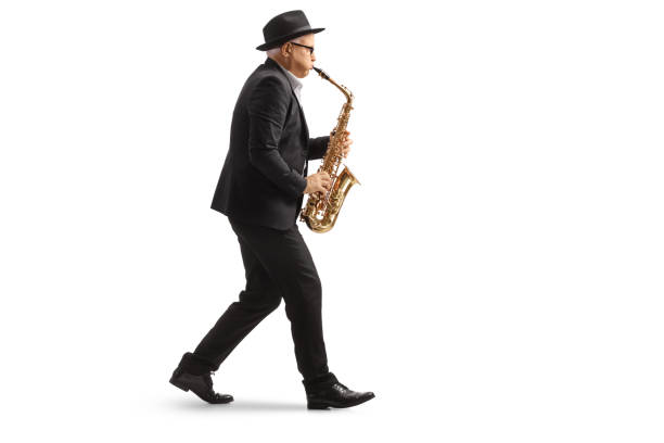 istock Full length profile shot of a man walkign and playing a sax 1787663163