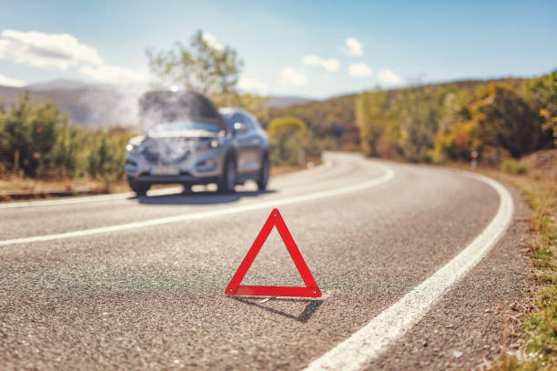 Red warning triangle on open road in front of a SUV