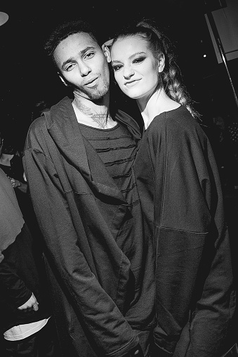 Group portrait of two young people. Multiracial group indoors, lifestyle black and white photography with handsome models. Black and white photography, backstage. Behind the scenes of fashion week show.