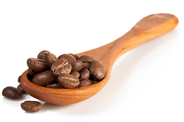 istock wooden spoon with coffee beans isolated over white 178766334