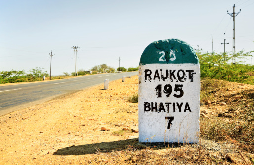 Horizontal color landscape of the 195 kilometers to Rajkot milestone on the Gujarat State Highway which runs through some of the most barren and wilderness land in India