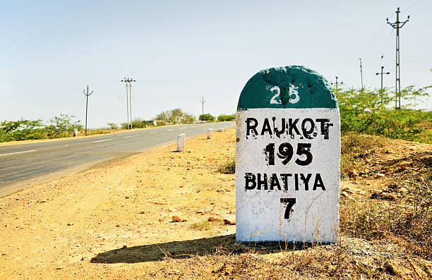 Rajkot 195 milestone on State Highway 25 Horizontal color landscape of the 195 kilometers to Rajkot milestone on the Gujarat State Highway which runs through some of the most barren and wilderness land in India rajkot india stock pictures, royalty-free photos & images