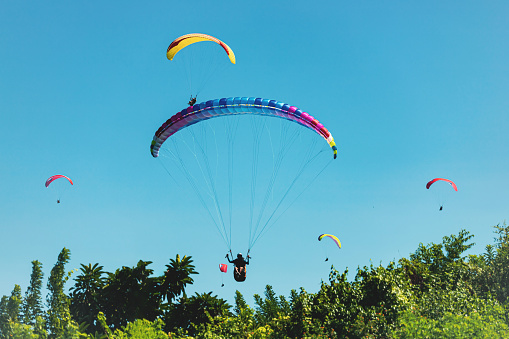 Paragliding sport, flying against the blue sky in An Giang province, Mekong Delta