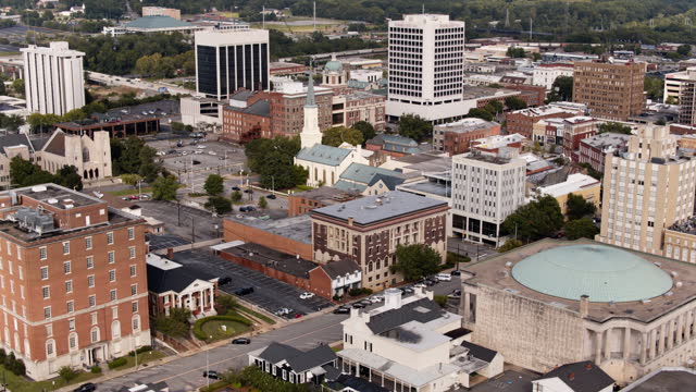 Macon City Auditorium and First Presbyterian Church on Mulberry Street in Downtown Macon, Georgia. Aerial footage with panning camera motion