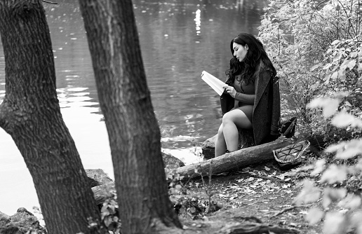 Attractive young woman reading a book in Central Park. It's the autumn season in New York