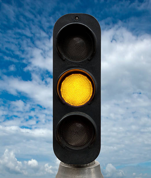 Yellow traffic lights Yellow traffic lights against blue sky backgrounds. Clipping Path included. blue yellow lights stock pictures, royalty-free photos & images