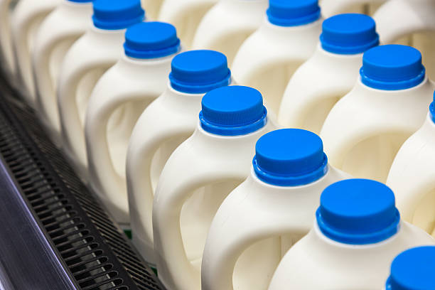 Several gallons of milk bottles in a store