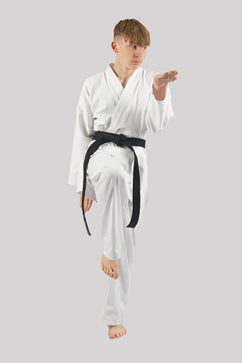 Black belt teenage boy performing kata