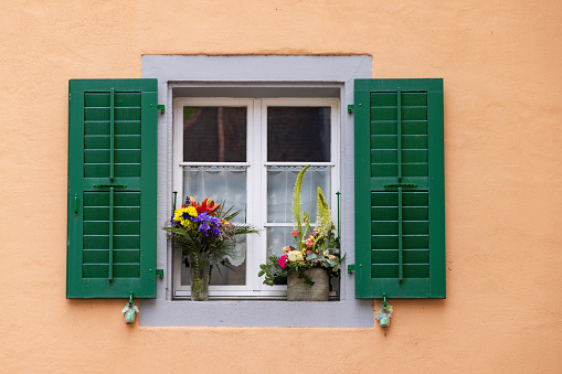 Beautiful house facade  with colorful shutters and flowers