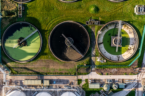 An aerial view directly above a waste water treatment works with circular storage tanks filtering wastewater for drinking water