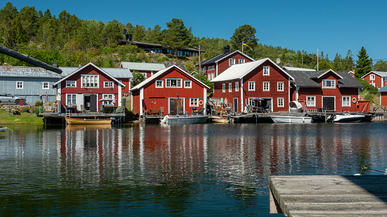 Characteristic, distinctive fishing village (Bönhamn) with small red houses in nature reserve Höga Kusten in central Sweden.
