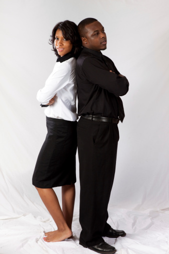 Black couple standing  back to back with arms crossed