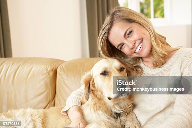 Young Woman With Dog Sitting On Sofa Stock Photo - Download Image Now - Dog, Lap - Body Area, 30-39 Years