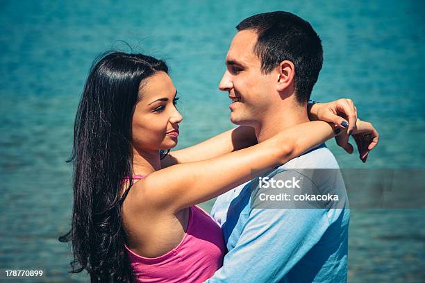 Young Couple In Hug Stock Photo - Download Image Now - Beach, Blue, Cheerful