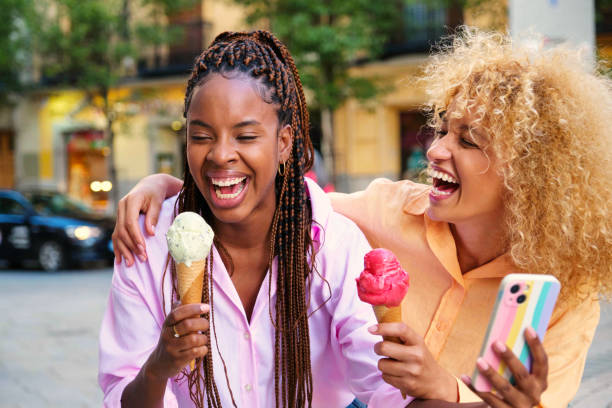 istock Two multiracial happy friends with ice creams laughing in summer. 1787718608