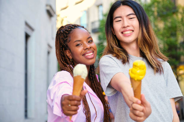 istock Two multiracial happy friends with ice creams smiling in summer. 1787718642