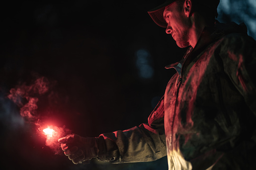 Caucasian Man with Burning Emergency Flare in His Hand During Night Hours