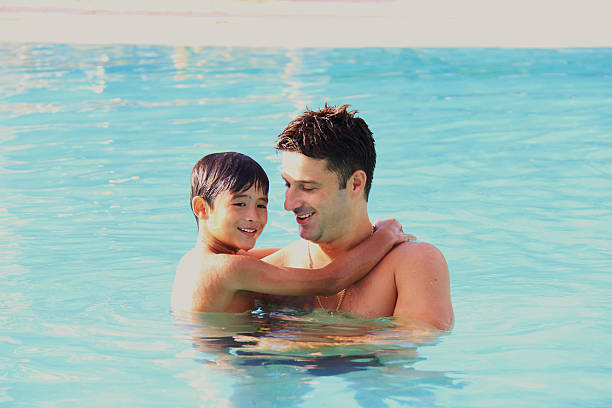 istock father and son having fun in the swimming pool 178772376