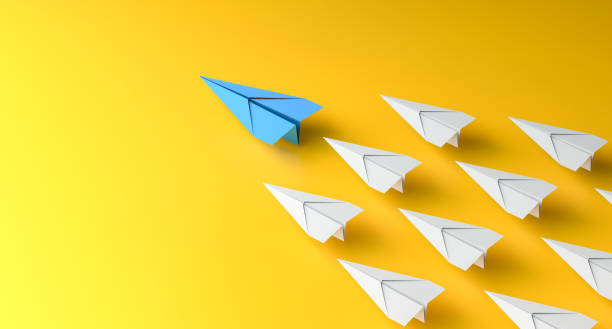 Leadership concept, blue leader plane leading white planes, on yellow background stock photo