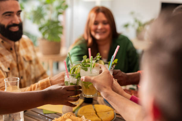 istock group of friends toasting with mojitos while enjoying food.focus on glasses 1787740996
