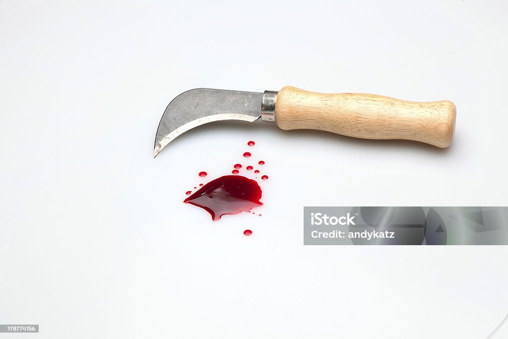 Deadly Tools Carpet cutting knife with wooden handle alongside blood splatter upon white background Aggression Stock Photo