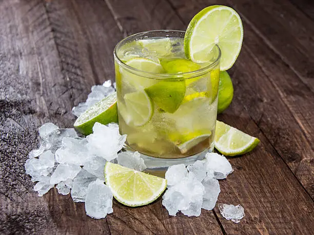Glass of Caipirinha with Crushed Ice on wooden background