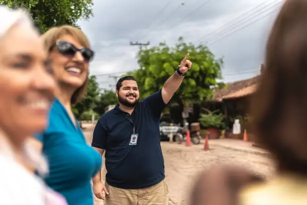 Photo of Private tourist guide showing and talking to tourists outdoors