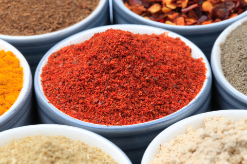 Variety of raw Authentic Indian Spice Powder on bowl. Focus on Chilli Powder in full-frame.