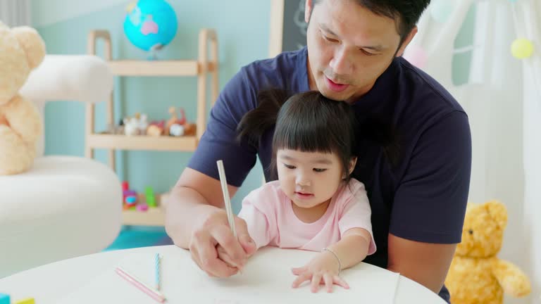 Asian father painting with kid