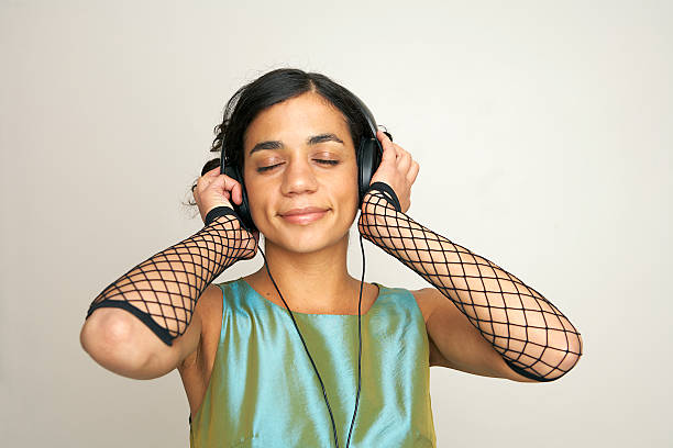 Girl with eyes closed listening to music on headphones stock photo