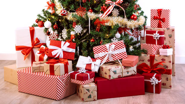 istock Beautiful wrapped gift boxes under a Christmas decoration tree home. Fir Xmas 1787820015