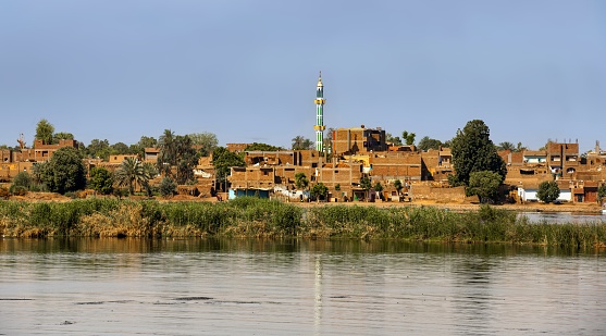 Kom Ombo, Egypt, April 14, 2023: View of a village and a mosque on the left bank of the Nile River in the spring morning.