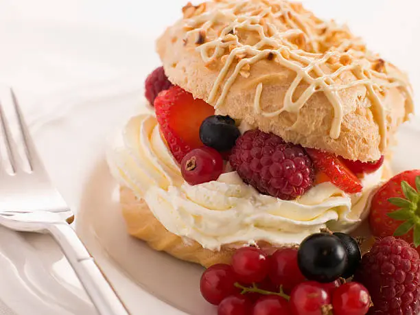 Choux Bun filled with Mixed Berries and Chantilly Cream  on White Plate