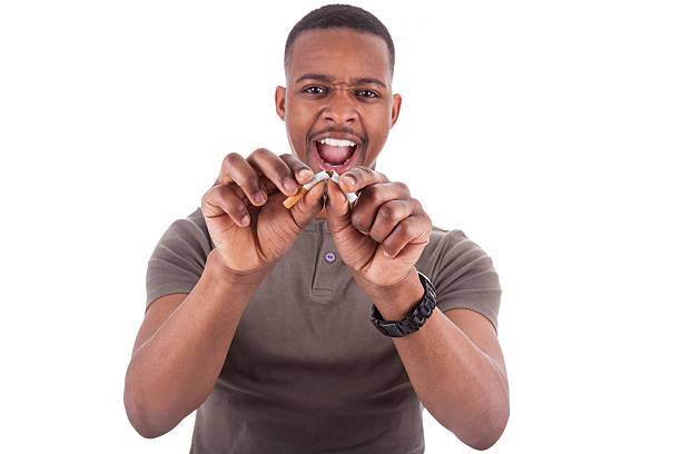 young african american man romper un cigarrillo - african descent addiction african ethnicity rudeness fotografías e imágenes de stock