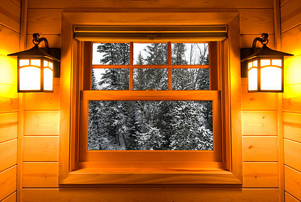 Inside view of a cedar cabin window with lights on