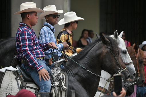 Oaxaca, Mexico - July 09, 2023: Mexican Cowboys riding beautiful horses at the parade in city street, Oaxaca, Mexico