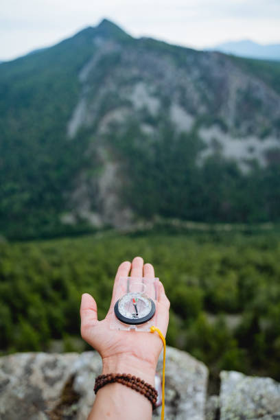 istock Orienteering on the terrain with a compass, a navigation device for extreme situations, a magnetic needle points north. 1787881612