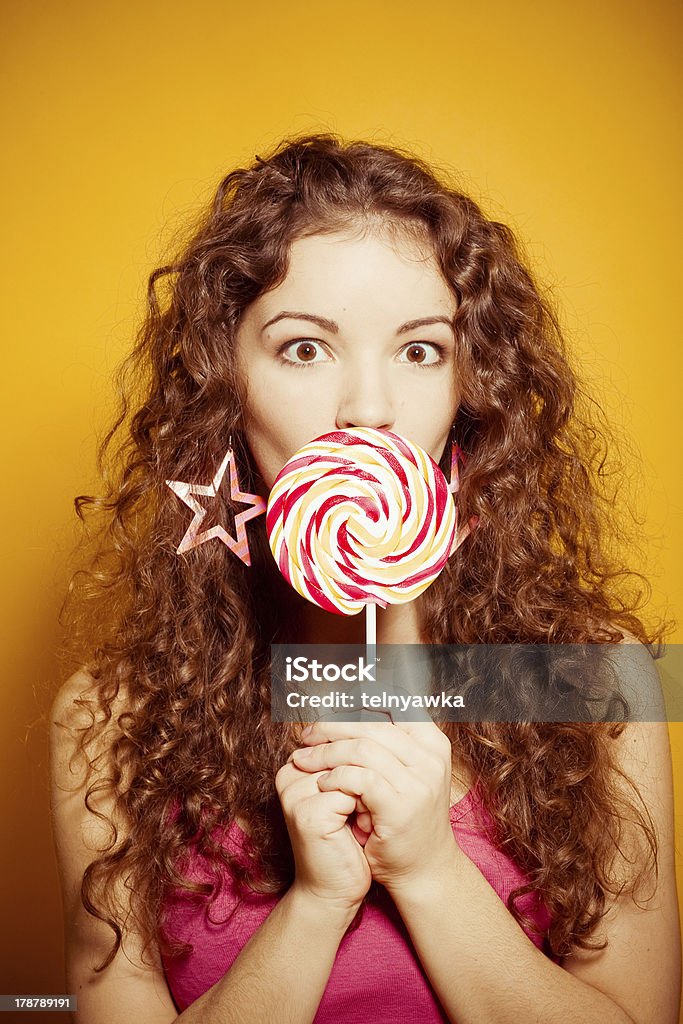 Felice giovane donna con Lecca-lecca - Foto stock royalty-free di Capelli crespi